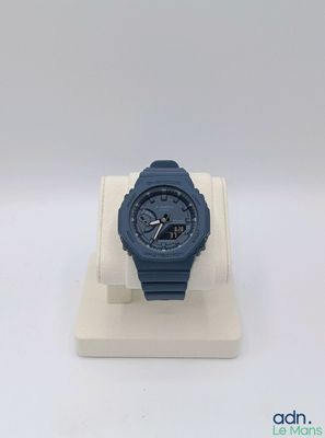 a close up of a watch on a display stand on a white surface