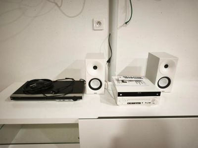 une table blanche sur laquelle se trouvent des haut-parleurs et un ordinateur portable