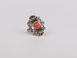 a close up of a silver ring with an orange stone