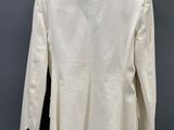a white jacket hanging on a hanger against a gray wall