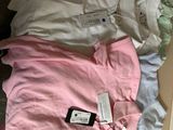 a pile of clothes and a cell phone on a bed