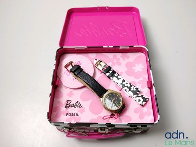a pink box with a watch and a watch in it