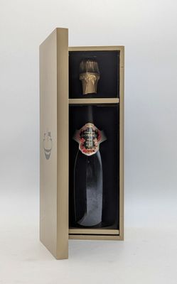 une bouteille de vin dans un coffret en bois orné d'un masque