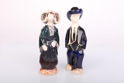 two figurines of a man and a woman standing next to each other