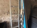 une échelle appuyée contre un mur, à côté d'un lit