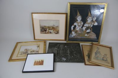 de nombreux tableaux encadrés posés sur une table, parmi lesquels une photo d'un homme