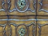 a wooden chest of drawers with brass hardware on it