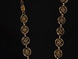 a close up of a necklace on a table with a black background
