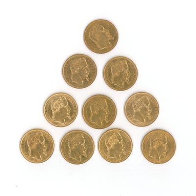 un gros plan sur une pyramide de pièces d'or posée sur une surface blanche