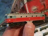 someone is holding a model of a train in their hand