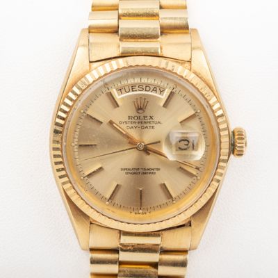 an image of a gold rolex watch on a white surface