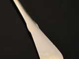 a close up of a spoon on a table with a black background