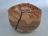 a small bowl with a tree on it on a table