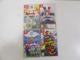 four nintendo wii games sitting on a white surface