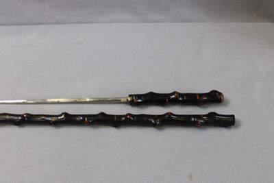 pair of black and gold canes on a white surface