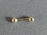 a close up of a gold nose piercing on a gray surface