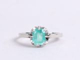 a close up of a ring with an emerald stone in it