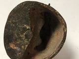a hand holding a metal object with a hole in it