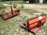 two farm equipment that are sitting in the grass