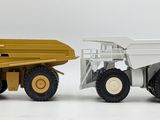 a yellow dump truck and a white dump truck