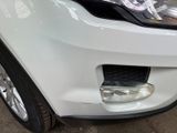 a close up of a white car that is parked in a garage