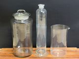 a glass pitcher and a glass jar on a wooden table