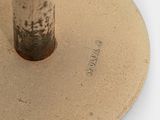 a metal pole with a brown base on a white surface