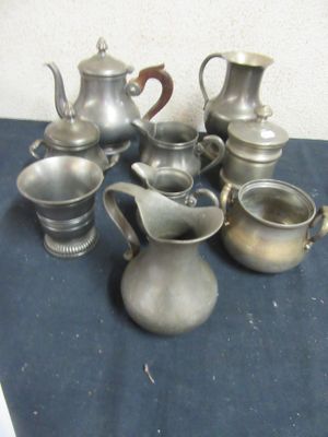 a lot of silver teapots and cups on a table