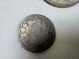 two silver coins sitting next to each other on top of a table