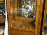 un meuble en bois avec une porte en verre au milieu d'une pièce
