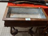 a table with a glass top and a gun on top of it