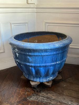 a large blue pot sitting on a wooden floor