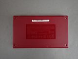 the back panel of a red laptop with a white sticker on it