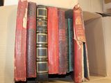 many books in a cardboard box on a shelf