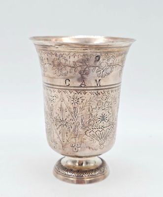 une tasse en argent antique avec un motif floral sur le bord