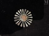 sterling silver broochle with pink stone in center on black background