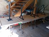 several pieces of wood sit on top of a table in front of a set of stairs