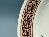 une assiette blanche bordée de marron