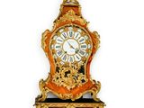 a clock that is on the wall with a gold decoration