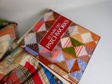 a book that is sitting on top of a pile of quilts