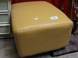 un pouf jaune posé devant un mur rouge