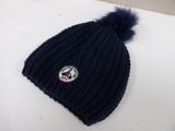 navy blue knitted hat with a pom pom on top of it