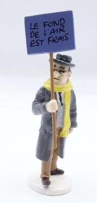figurine of a man holding a sign that says le fond de l ' air est foas