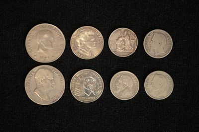 six different types of coins are shown on a black surface