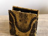 a close up of a snake skin wallet on a wooden table