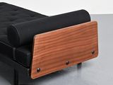 a black couch with a wooden arm rest on the floor