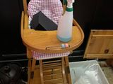 une chaise haute pour bébé sur laquelle sont posés une bouteille d'eau et un vaporisateur