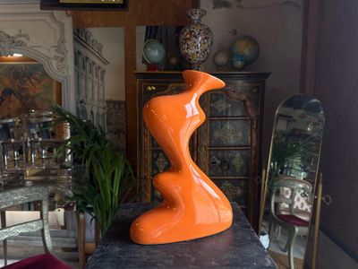 an orange sculpture sitting on top of a table in a room