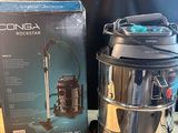 une photo d'un aspirateur posé sur une table, à côté d'une boîte