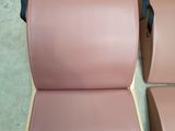 three pink leather chairs sitting on top of a floor next to each other